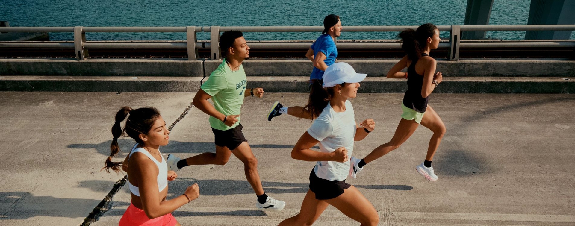 A group of people exercising, running down a city street, wearing Brooks shoes