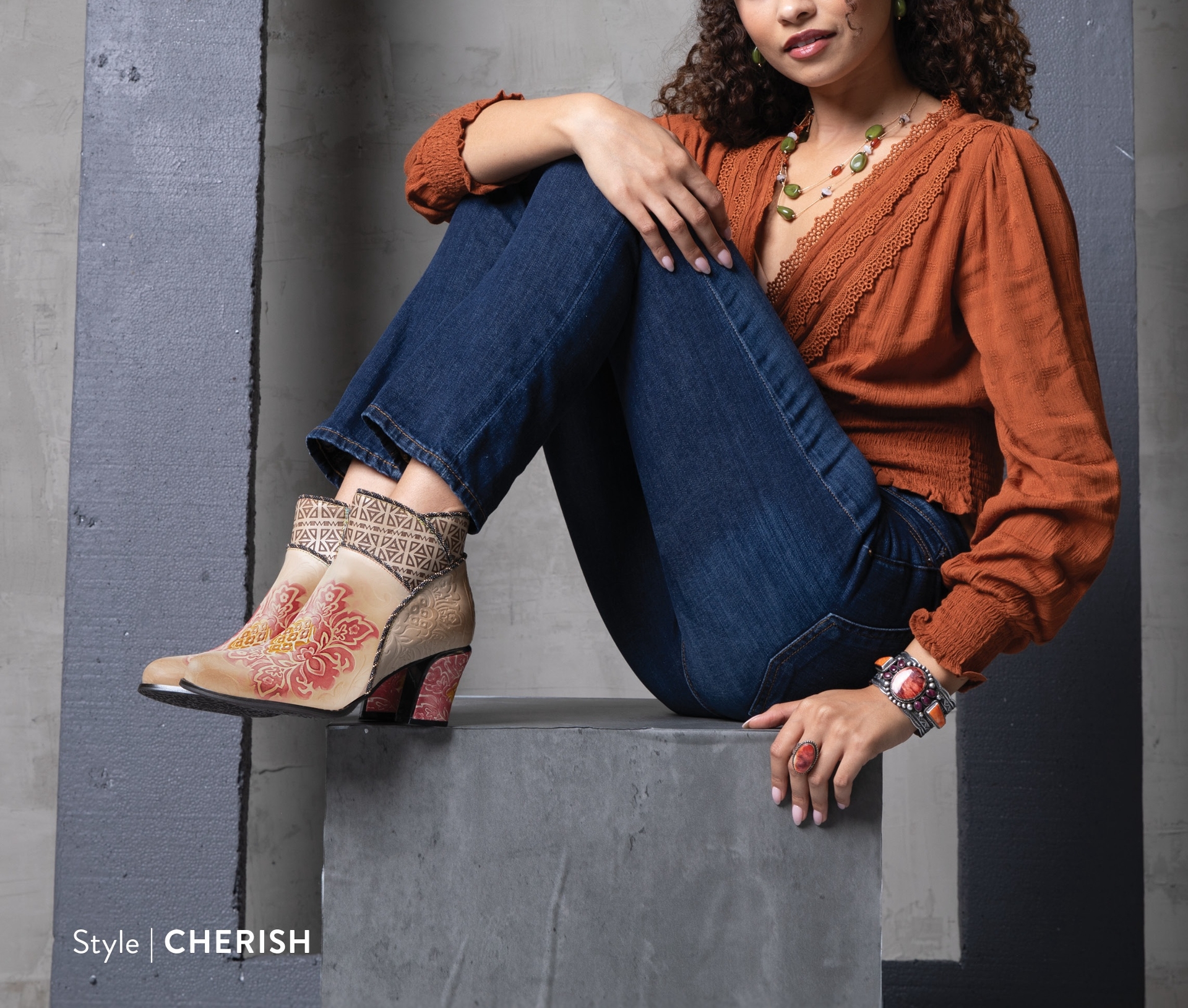 woman sitting in with her feet up, wearing a heeled boot 