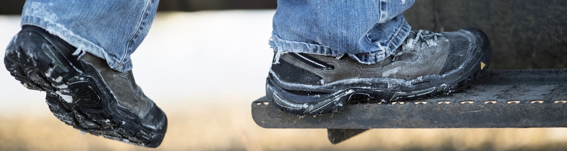 Feet in snow covered shoes stepping up onto truck