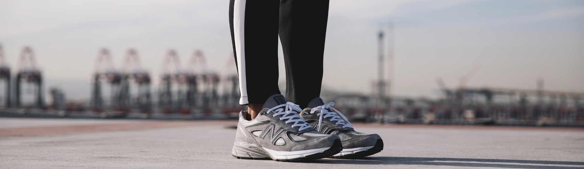 Woman in leggings in sweats and running shoes on open pavement